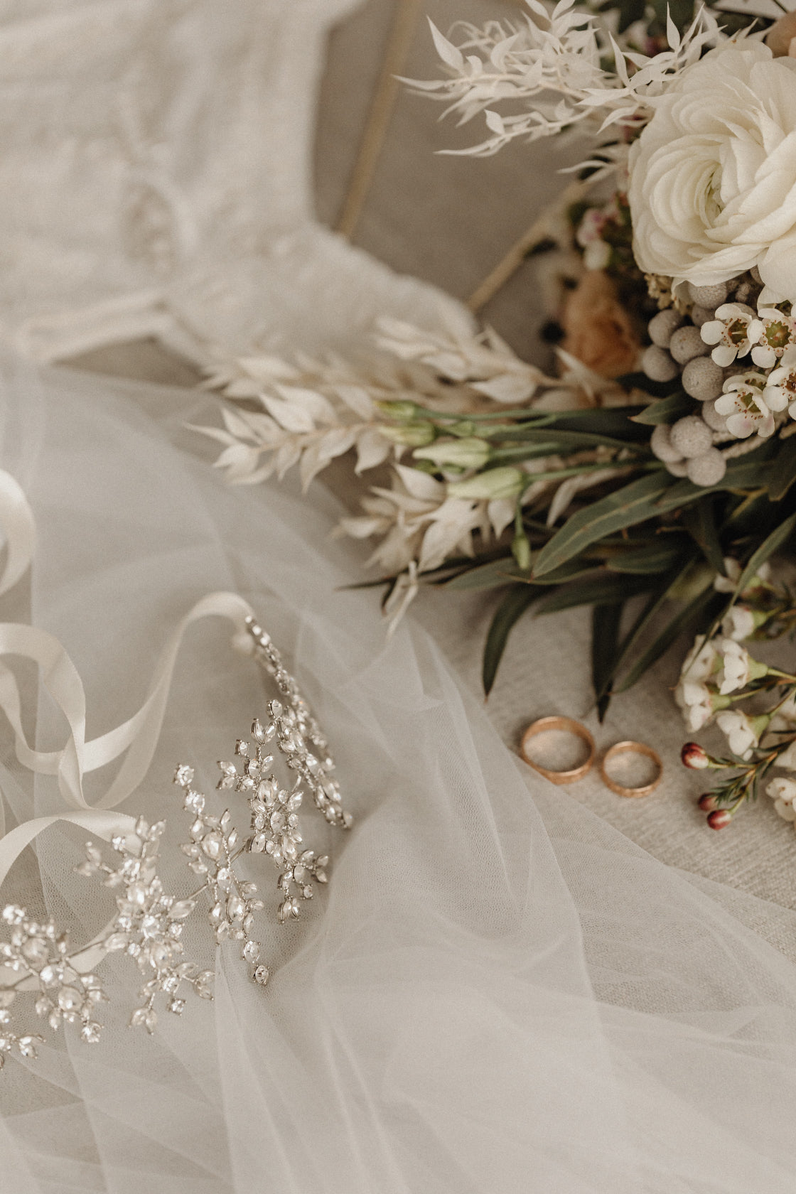 Brautaccessoires mit Trauringen, Blumenstrauß und Schleier als Symbol für Hochzeitsjubiläum und Ehefeier: Silberhochzeit, goldene Hochzeit, diamantene Hochzeit